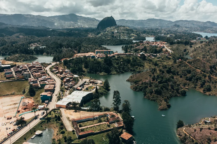 An aerial view of a lakeside town and a prominent rock formation.